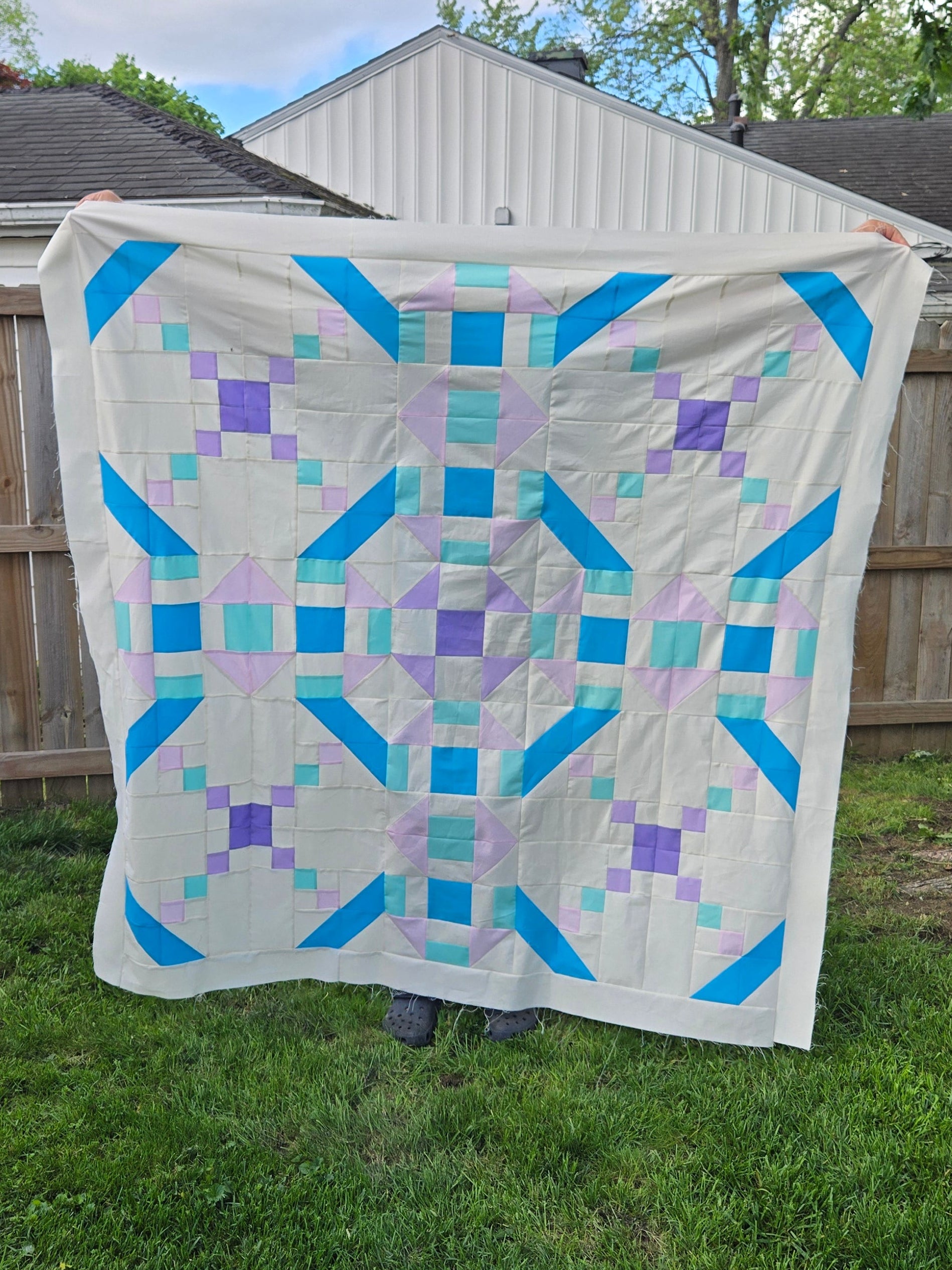 Quilt with geometric pattern hanging on a clothesline outdoors